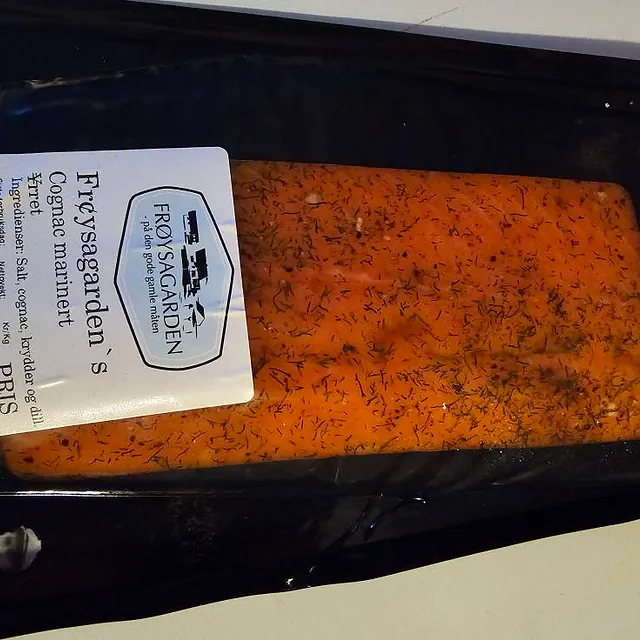 Pakke med Frøysagarden’s cognacmarinerte ørret, med dill og krydder synlig gjennom plasten.