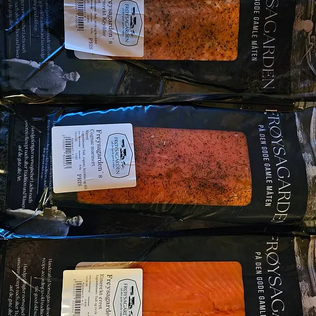 Tre ulike vakuumpakkede ørretprodukter fra Frøysagarden, liggende på rekke.